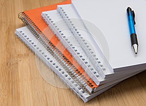 Stack of white and orange Personal office notebooks