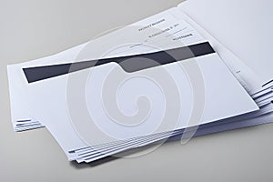A stack of white paper with a black and white folder in the middle