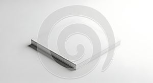 A square stack of white paper sitting on a white surface with soft shadows