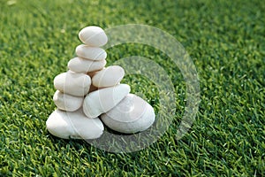 Stack of white pebble stones on artificial grass