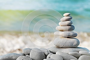 Stack of white pebbles stone against blue sea background for spa, balance, meditation and zen theme. photo