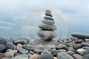 Stack of white pebbles stone against blue sea background for spa, balance, meditation and zen theme