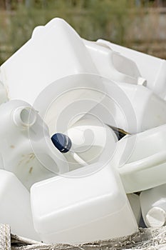 Stack of white plastic bottles for recycling.