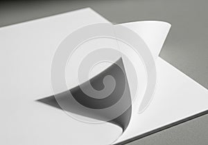A stack of white sheets of paper with the top corner turned