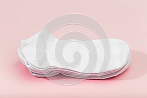 Stack of white socks on pink background