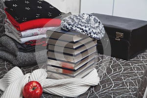 Stack of winter clothes and books with glossy edge