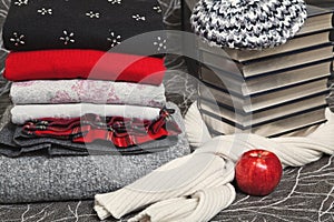 Stack of winter clothes and books with silver edge