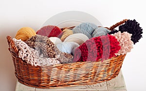 Stack of knitted hats and yarns in a basket