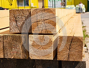 A stack of wooden balks, wooden balks, beams at a sawmill, a warehouse of beams on the site of a building materials store. Wood,