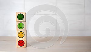 Stack of Wooden Feedback Cubes with Smile Neutral and Sad Faces for Rating Scale