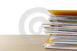 Stack of yellow files with documents on wooden table against white background. Space for text