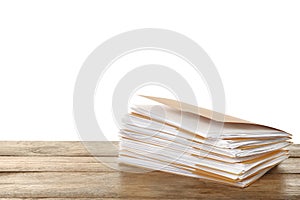 Stack of yellow files with documents on wooden table against white background. Space for text