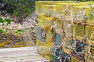 Stack of yellow lobster traps on short dock