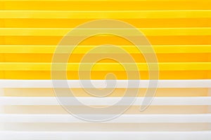 Stack of yellow and white recycled plastic containers. Duocolor background