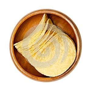 Stackable salted potato chips, potato-based crisps, in wooden bowl