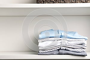 Stacked baby clothes on shelf