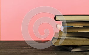 Stacked books on pink background