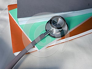 stacked books and stethoscope on the white fabric