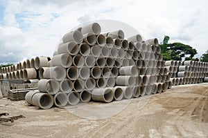 Stacked cement drainage pipes at concrete factory. Reinforced concrete pipes. Industry manufacturing concept.