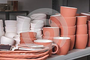 Stacked ceramic bowls, pots, dishes and mugs, clay handmade products after baking in kilns in the potter`s studio