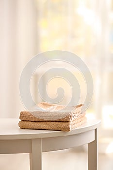 Stacked clean towels on table in light room