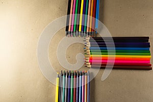 Stacked colored pencils. Isolated on brown background