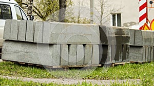 stacked concrete pavement blocks lie on the grass,background