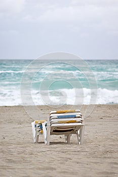 Stacked empty sunbeds on a beach