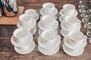 Stacked empty teacups with teaspoons at a function over