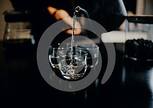 stacked glasses, in a cafe, being poured mineral water using a teapot, Aceh