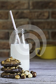 Stacked hazelnut and chocolate chip cookies on brick background