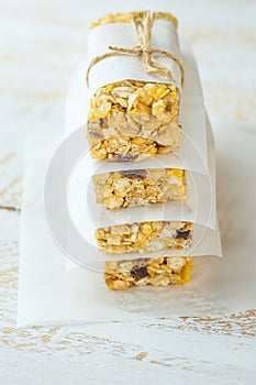 Stacked Homemade Granola Muesli Cereal Bars with Oats Nuts Raisins Honey Dried Apples. Lined with Parchment Paper Tied with Twine.