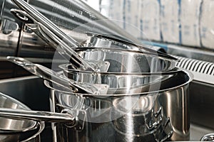 Stacked industrial metal cooking pots on proffesional kitchen