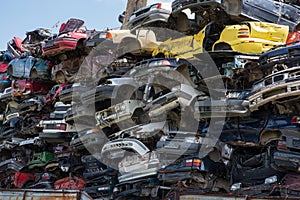 Stacked junk yard clunker cars prepared for recycled