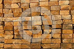 Stacked lumber pile, close-up of cut wood logs for timber industry. Forestry texture background, sawn wooden beams in