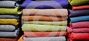 Stacked multicolored clothing fabric in the closet bed linen banner.