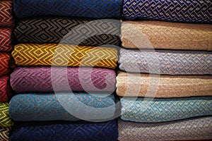 Stacked multicolored clothing fabric in the closet bed linen banner.