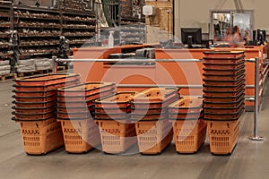 Stacked orange baskets for carrying purchases in a DIY supermarket
