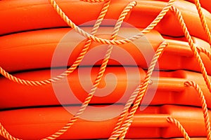 Stacked orange rescue round buoy, sea marine lifesaver.