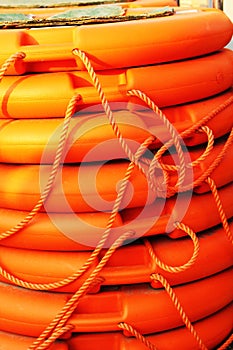 Stacked orange rescue round buoy, sea marine lifesaver