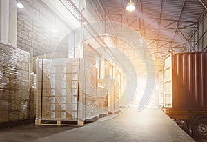 Stacked of Package Boxes on Pallets Loading with Shipping Cargo Container. Truck Parked Loading at Dock Warehouse.