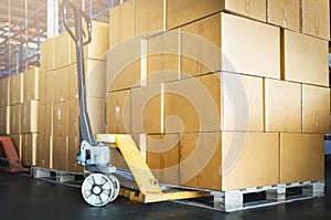 Stacked of Package Boxes on Wooden Pallet and Hand Pallet Truck at Storage Warehouse. Shipment Boxes. Cargo Export- Import.