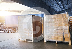 Stacked of Package Boxes Wrapped Plastic on Pallets Load with Shipping Cargo Container. Truck Parked Loading at Dock Warehouse.