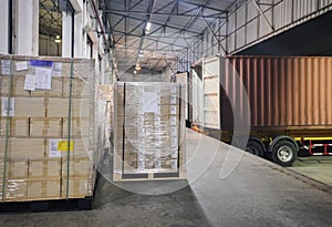 Stacked of package boxes wrapping plastic on pallet waiting to load into shipping container. Cargo shipment boxes, Freight truck.