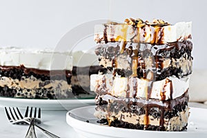 Stacked pieces of creamy chocolate, vanilla and mocha layered ice cream pie with the full pie in behind.