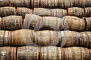 Stacked pile of old whisky and wine wooden barrels