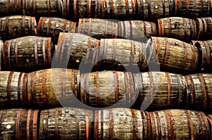 Stacked pile of old whisky and wine wooden barrels