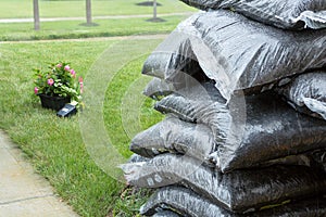 Stacked plastic bags of mulch and flowers in rain