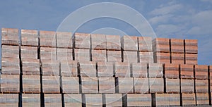Stacked red bricks stored on pallets for construction use