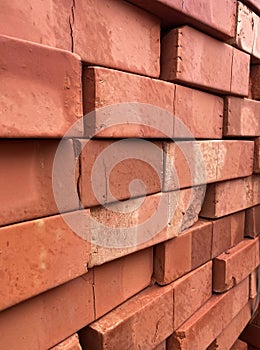 Stacked red clay bricks for construction